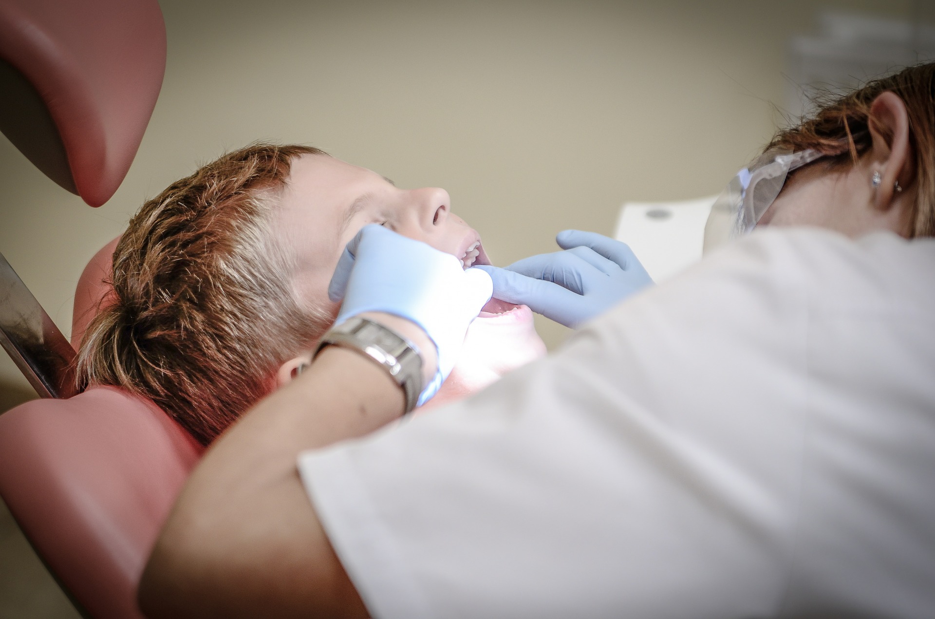 This image shows a young boy getting a dental checkup.
